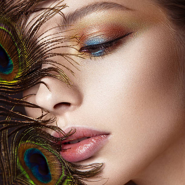 hermosa chica con maquillaje de color brillante y pluma pavo real - stage makeup peacock make up feather fotografías e imágenes de stock