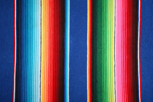 Stack of colorful, traditional Peruvian fabrics. Market in Pisac village, Sacred Valley, Peru. The Sacred Valley of the Incas or Urubamba Valley is a valley in the Andes  of Peru, close to the Inca  capital of Cusco and below the ancient sacred city of Machu Picchu. The valley is generally understood  to include everything between Pisac  and Ollantaytambo, parallel to the Urubamba River, or Vilcanota  River or Wilcamayu, as this Sacred river is called when passing through the valley. It is fed by  numerous rivers which descend through adjoining valleys and gorges, and contains numerous  archaeological remains and villages. The valley was appreciated by the Incas due to its special  geographical and climatic qualities. It was one of the empire's main points for the extraction of  natural wealth, and the best place for maize production in Peru.http://bem.2be.pl/IS/peru_380.jpg