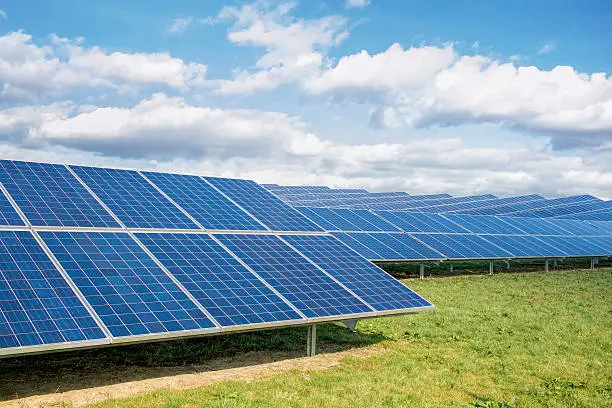 Photo of Solar Farm. Green Fields Blue Sky, Sustainable Renewable Energy.