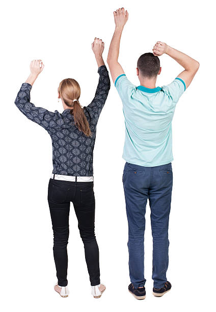 istock Back view of  joyful couple celebrating victory hands up. 512629857