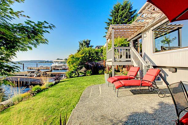 istock Waterfront back yard, patio with red chairs, and Lake washington. 512631456