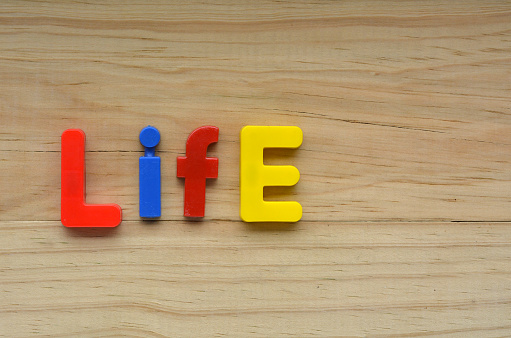 Flat lay of the word Life on a wooden background.  Relationship concept with copy space for text