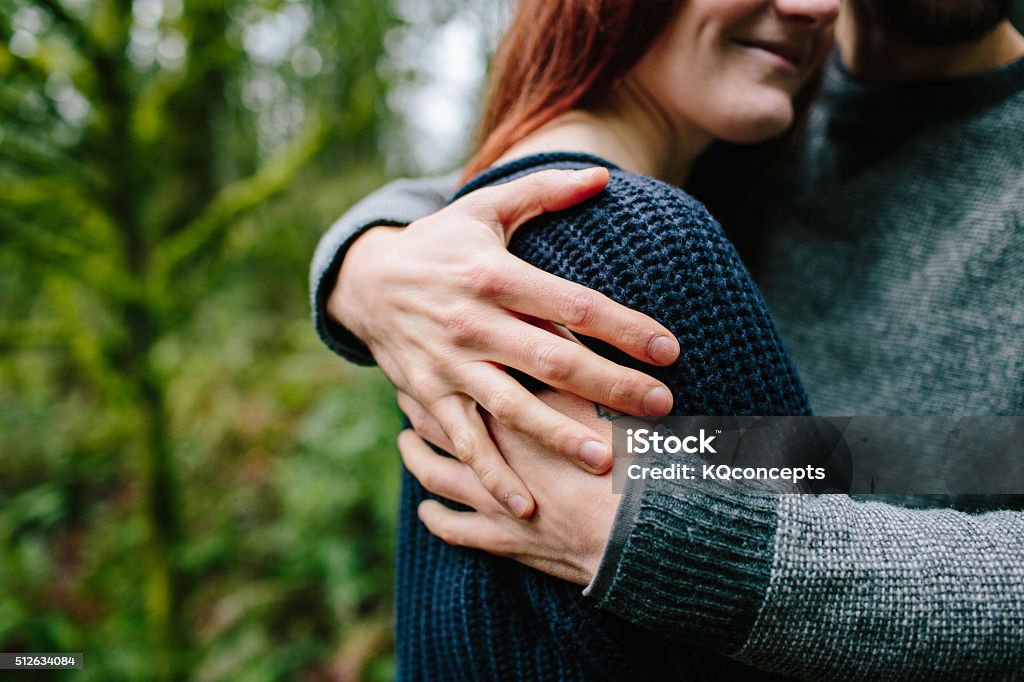 Couple embraces in the woods A young couple pause during their hike to enjoy a moment and a hug. Couple - Relationship Stock Photo