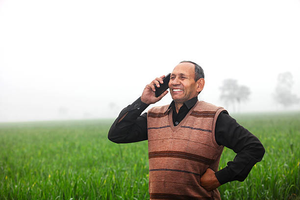 istock Farmer talking on the phone in green wheat field 512637720