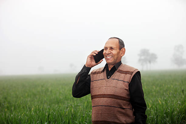 istock Farmer talking on the phone in green wheat field 512637738