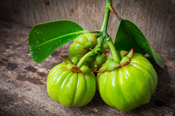 Still life with fresh garcinia cambogia on wooden background (Th stock photo
