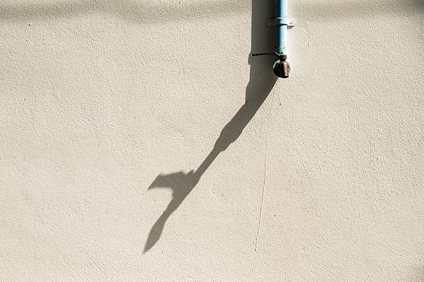 istock Shadow of a faucet on a white wall. 512640262