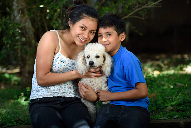 istock boy and girl with poodle 512682518