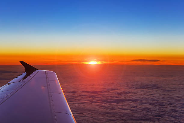 istock Airplane wing in flight above the clouds at the sunset background 512683742