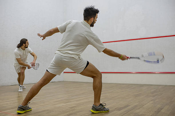istock Young athletes in white playing squash on a court. 512685884