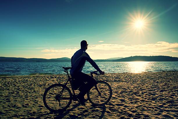 istock Cyclist on the sunny beach. Spring season at lake. 512688648