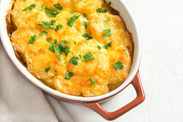 Potato gratin with cheese Potato gratin with cream, cheese and parsley in baking dish seafood gratin stock pictures, royalty-free photos & images