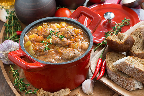 istock vegetable stew with sausages in a red pan 512691807