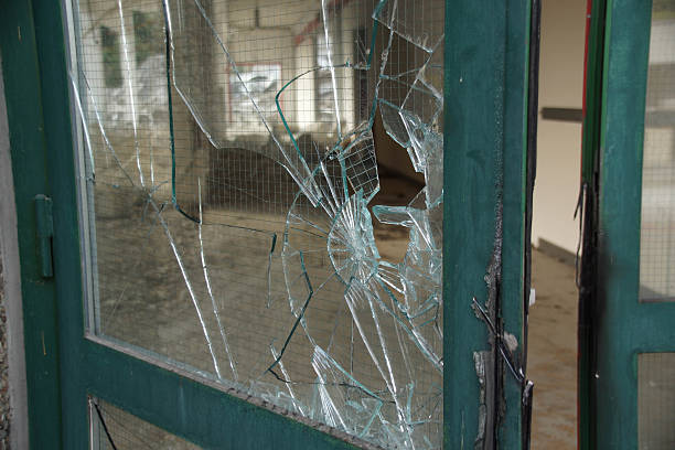 istock Broken glass door with green metal frame 512692219
