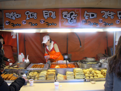 Seoul, South Korea - March 4, 2012: Unidentified Korean woman sells traditional street food i.e. fish ball stick at Gangnam district, Seoul in South Korea.