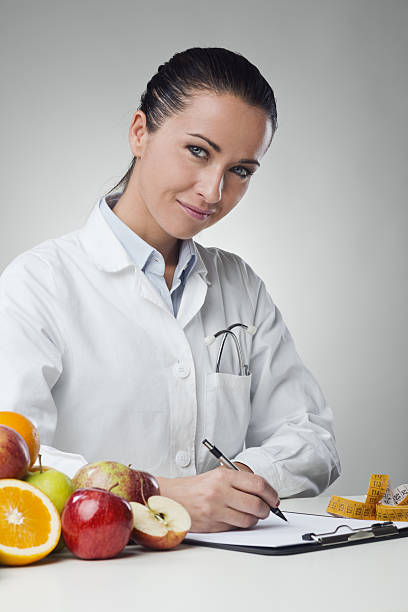 istock Smiling nutritionist writing medical records 512694124