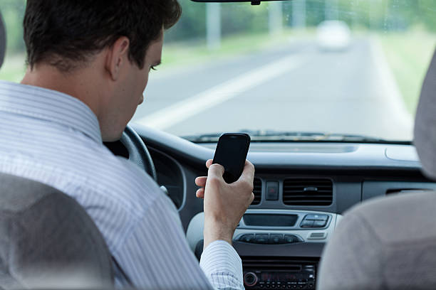 istock Man texting on mobile phone during driving a car 512694913