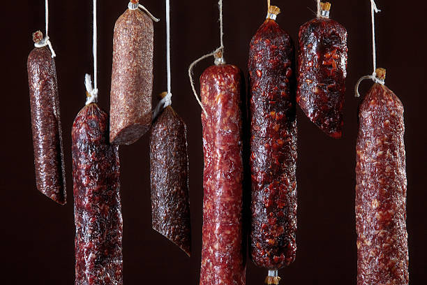 istock various hanging salami sausages 512695371