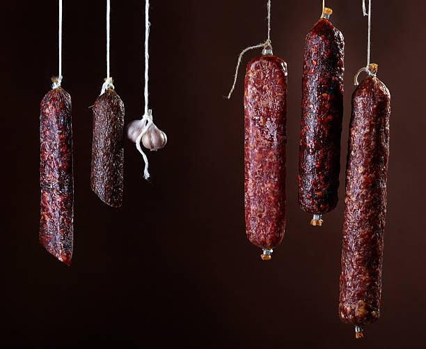 istock various hanging salami sausages 512695399