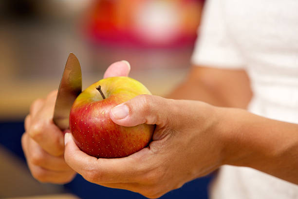 istock Female hands slicing apple with knife 512695701