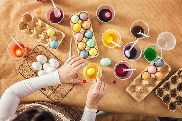 Coloring Easter Eggs with Natural Dye Coloring Easter eggs with a natural dye. Receipe for homemade dye - Add a quarter of water, tablespoon salt, 2 table spoons vinegar and the vegetable or spice in which color you like. Bring to boil and simmer for fifteen minutes, then remove pot from the burner. With the cold dye you can color the boiled eggs. easter egg coloring stock pictures, royalty-free photos & images