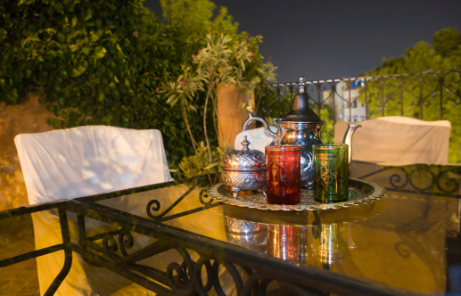 Moroccan tea party set up in a warm oriental candlelights atmosphere at night