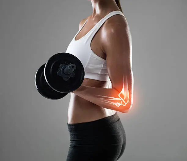 Shot of a woman holding a dumbbell with her elbow joint highlighted
