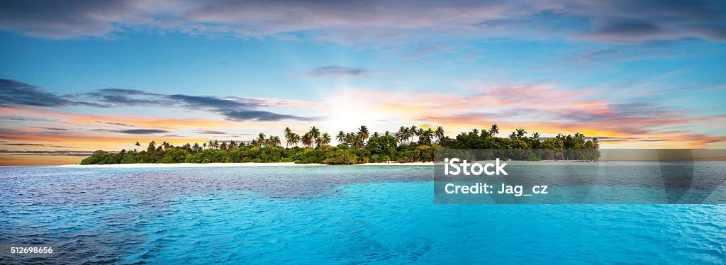 Beautiful nonsettled tropical island in sunset Beautiful nonsettled tropical island with perfect sunset sky and azure water with corals Island Stock Photo