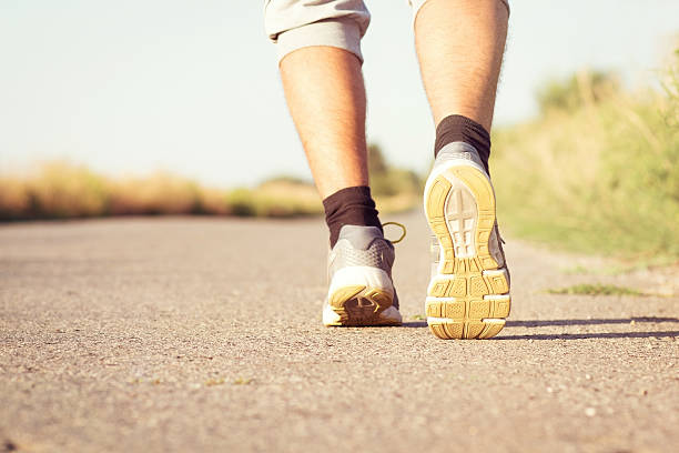 istock man's running legs on the paved road 512699308