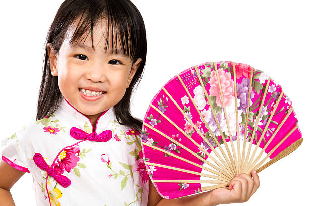 Asian Little Chinese Girl Holding Oriental Fan Asian Little Chinese Girl Holding Oriental Fan isolated on White Bakground oriental culture stock pictures, royalty-free photos & images