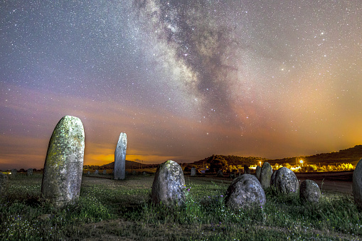 Central region of the Milky Way galaxy in the background of Xerez Cromlech, a stone megalithic monument consists of 50 granite menhirs erected between the 3rd and 4th millennium BC. Monsaraz, Alqueva Dark Sky, Portugal