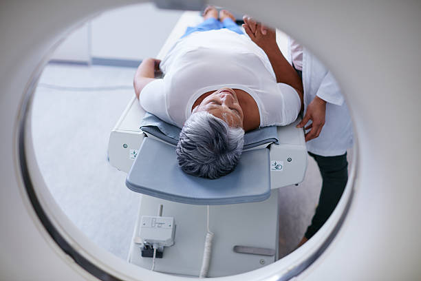 Preparing for the scan Shot of a senior woman being comforted by a doctor before and MRI scanhttp://195.154.178.81/DATA/i_collage/pu/shoots/806398.jpg tomography stock pictures, royalty-free photos & images