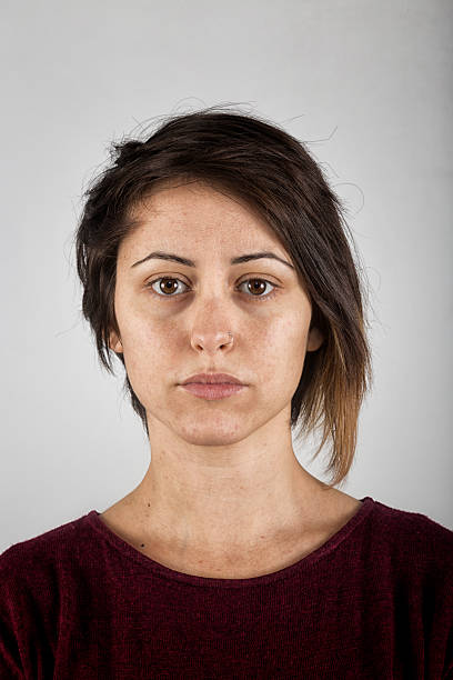 Portrait of a real adult woman looking at camera Studio portrait of a real adult european woman looking at camera with relaxed expression. The woman has around 40 years and has dark hair. Vertical color image from a medium format digital camera. Sharp focus on eyes personaje stock pictures, royalty-free photos & images