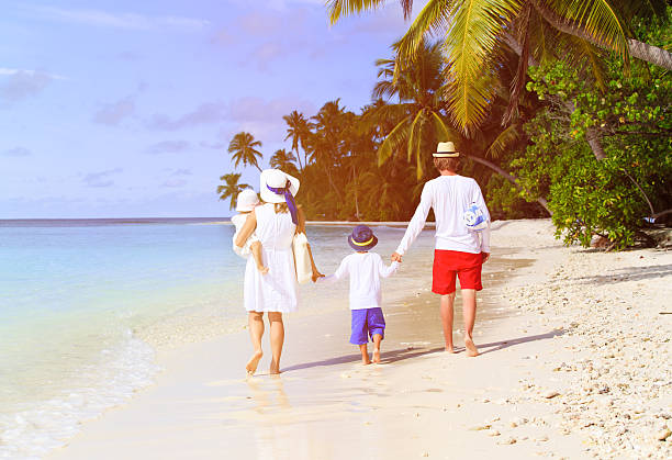 istock family with two kids walking at tropical beach 512725828