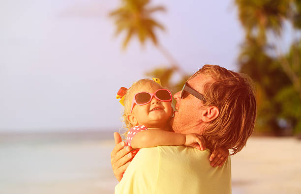 istock father and cute little daughter at beach 512727218