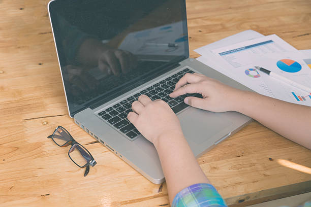 istock woman hand, pen, glasses, business document, laptop computer not 512728148
