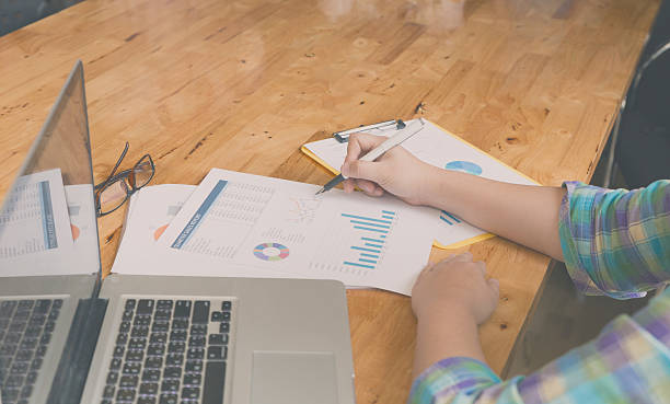 istock woman hand, pen, glasses, business document, laptop computer not 512728496