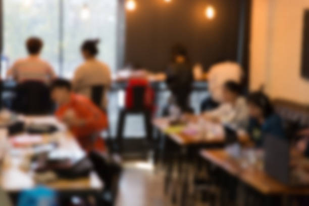 istock blurry defocused image of people working in cafe 512730180