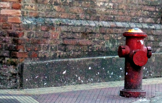 Fire hydrant wiyh brick wall in São Paulo city, Brazil.