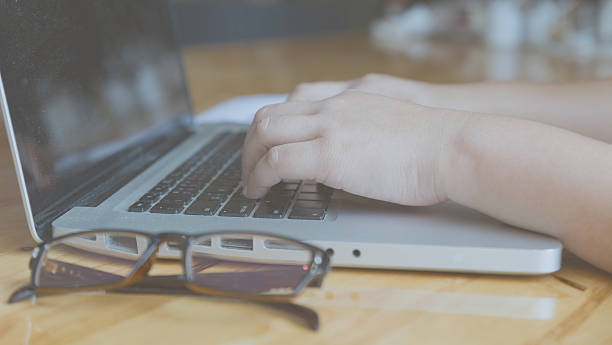 istock woman hand, glasses, business document, laptop computer notebook 512734354