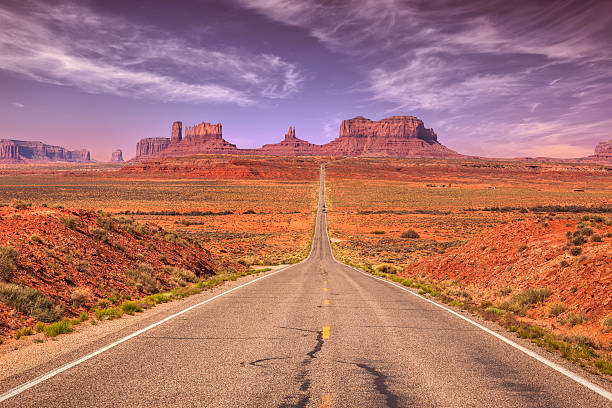 Road to Monument Valley View towards Monument Valley from the US Route 163 in Utah. monument valley photos stock pictures, royalty-free photos & images