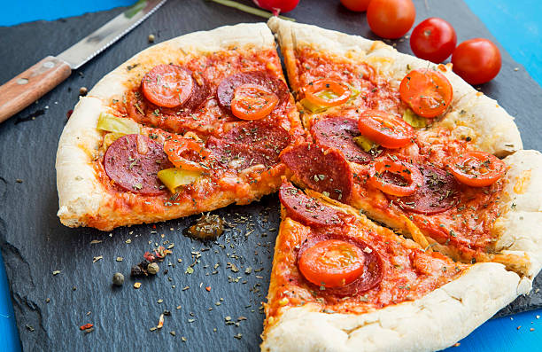 istock Pizza with salami meat, cherry tomatoes and oregano spice 512735696