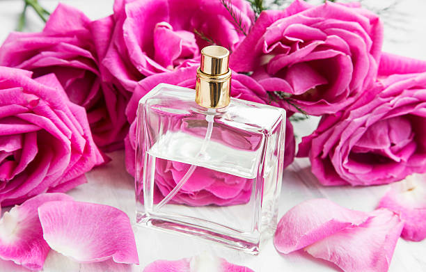 istock Roses perfume in transparent bottle with pink roses and petals 512735722