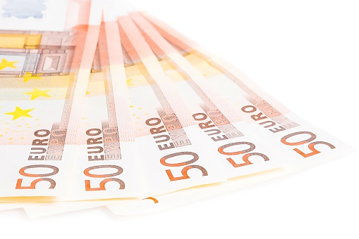 crisis of eurozone, detail of some 50-euro banknotes on white background