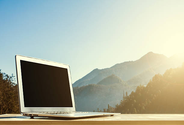 istock Laptop on wooden table with mountain background 512740626
