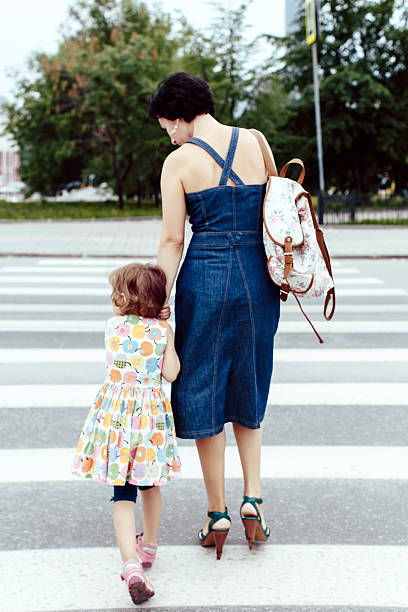 istock Daughter with her mother crossing the road 512741044