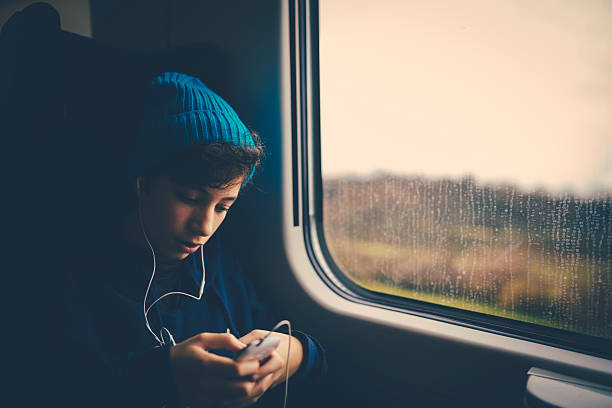 Girl on Train using smartphone stock photo