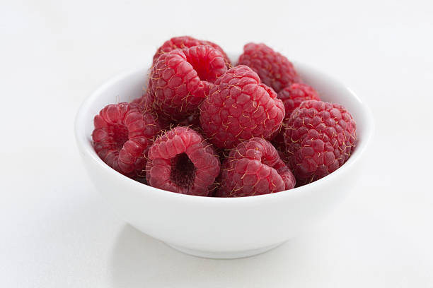 istock cup of fresh raspberries on a white background, closeup 512743820