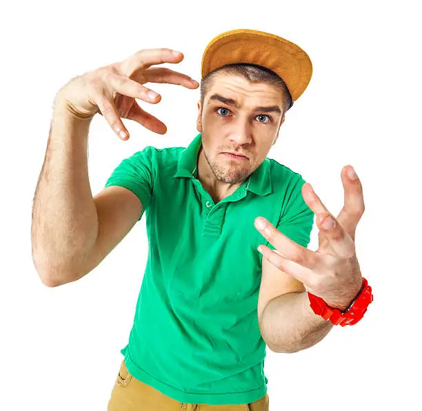 Portrait of young man b-boying in studio isolated on white background.