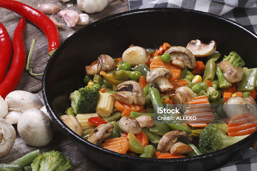 fried mushrooms with vegetables in a pan closeup fried mushrooms with vegetables in a frying pan. on the table. closeup. horizontal Asian Culture Stock Photo